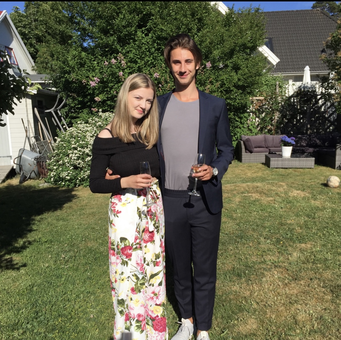 Agnes och David uppklädda i en sommarträdgård